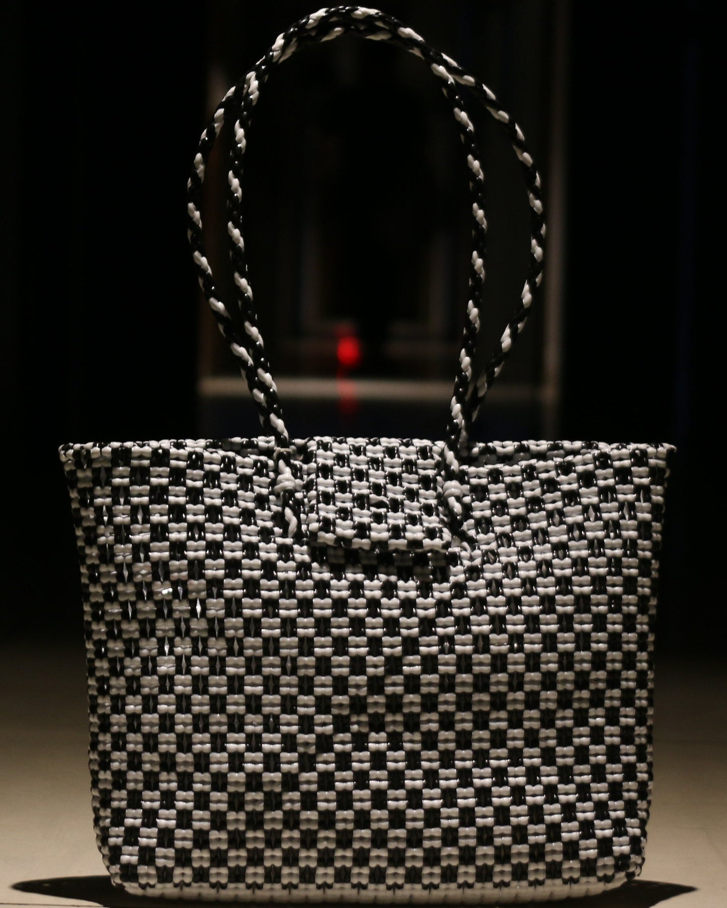 Black and white knitted handbag on a dark background