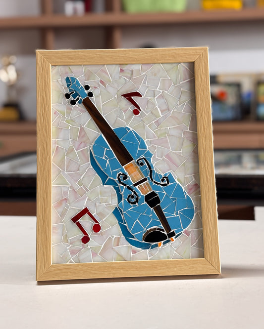 Mosaic artwork of a violin in a wooden frame on a blurred background
