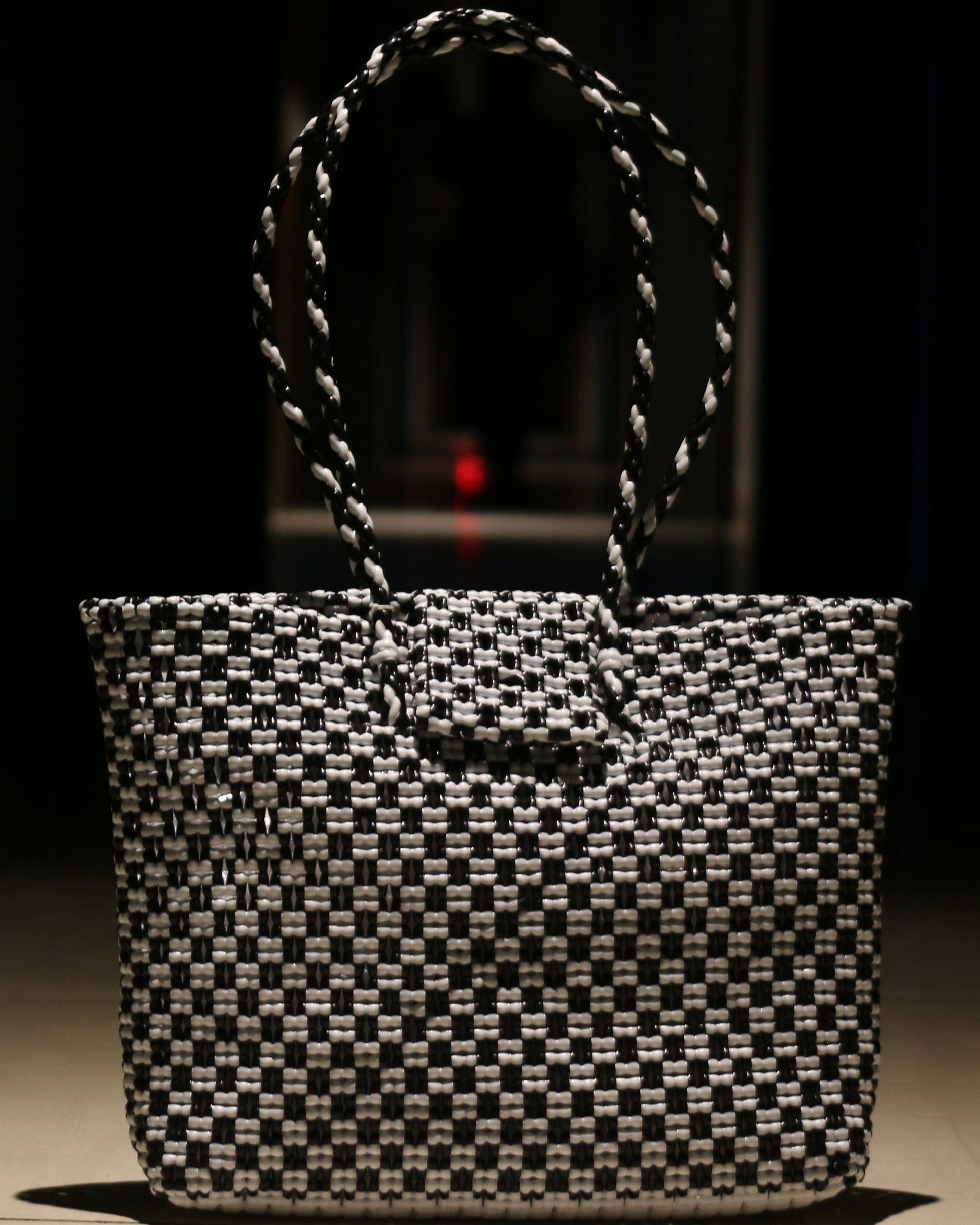 Black and white knitted handbag on a dark background
